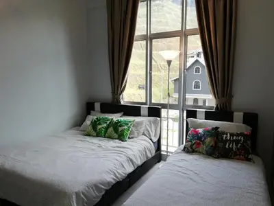 a bedroom with two beds and a large window at COOL Stay Cameron Golden Hills in Brinchang