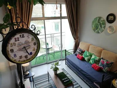 a clock in a living room with a couch and a window at COOL Stay Cameron Golden Hills in Brinchang
