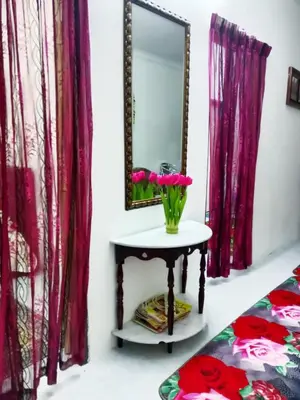 a mirror and a table with flowers on it at Homestay Kak Kiah Taiping in Taiping