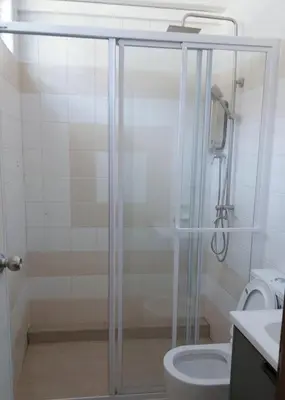 a bathroom with a shower and a toilet at Gracious Green Gurney in George Town
