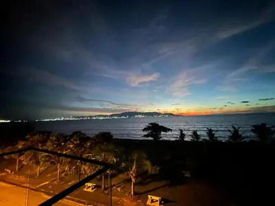a view of the ocean at sunset with palm trees at Mega Seaview Escape - Butterworth Penang in Butterworth