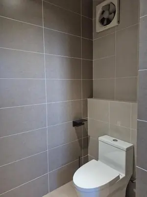 a bathroom with a toilet and a tile wall at Mega Seaview Escape - Butterworth Penang in Butterworth