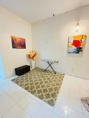 a living room with a rug and paintings on the wall at Effa Homestay in Sungai Petani