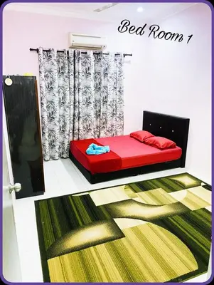 a bed room with a red couch and a green rug at Nizaman's Homestay Gerik in Gerik