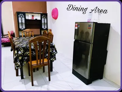 a kitchen with a dining area with a table and a refrigerator at Nizaman's Homestay Gerik in Gerik