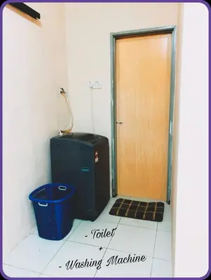 a bathroom with a toilet and a door with a basket at Nizaman's Homestay Gerik in Gerik