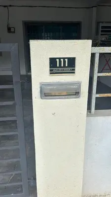 a white box with a clock on it in front of a building at Nizaman's Homestay Gerik in Gerik