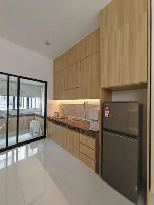 a kitchen with wooden cabinets and a stainless steel refrigerator at Ipoh M Villa in Ipoh