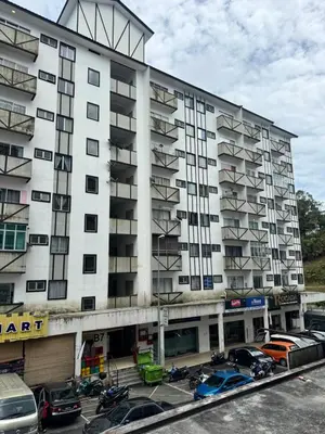 a large white building with cars parked in a parking lot at AYAAN Prima Homestay 1 with Netflix in Tanah Rata