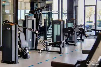 a gym with a row of treadmills and exercise bikes at 22 Macalisterz's Armoire Collection by ALV in George Town