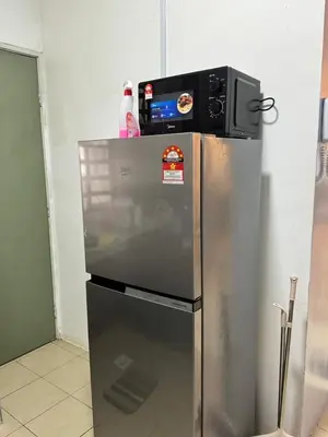 a refrigerator with a microwave on top of it at AYAAN MUSLIMAH Home at Tanah Rata in Tanah Rata