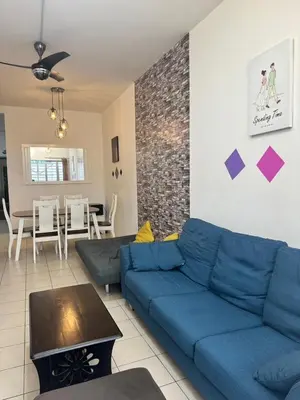 a living room with a blue couch and a table at AYAAN Budget Homestay at Tanah Rata in Tanah Rata