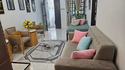 a living room with two couches with pillows at Rumah Inap Haziq in Seri Manjung