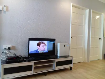 a flat screen tv sitting on top of a entertainment center at Fastbook Sun Moon City Home 12Pax in Ayer Itam