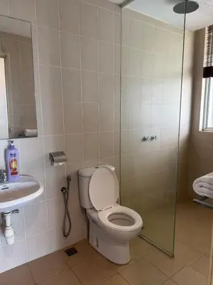 a bathroom with a toilet and a shower and a sink at Deluxe Apartment at CintaSayang Resort in Sungai Petani