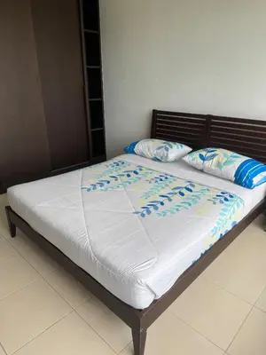 a bed with white sheets and blue pillows on it at Premium Condo at Cinta Sayang Club in Sungai Petani