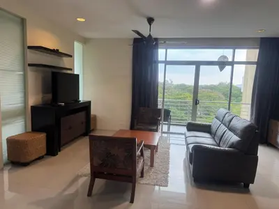 a living room with a couch and a table at Executive Apartment at Cinta Sayang Club in Sungai Petani