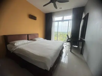 a bedroom with a bed with a ceiling fan and a window at Executive Apartment at Cinta Sayang Club in Sungai Petani