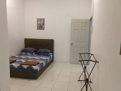 a bedroom with a bed and a clock on the wall at Homestay Rumahku Jana in Kamunting