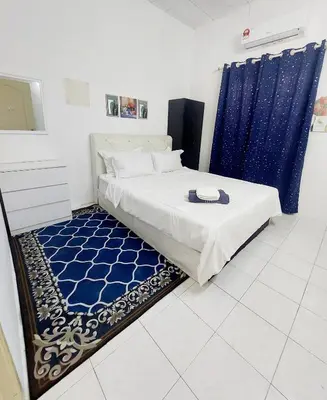 a bedroom with a bed and a blue curtain at Fz North Meru Impian in Ipoh