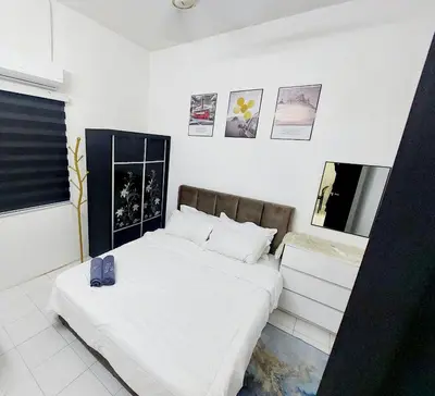 a bedroom with a bed with white sheets and pictures on the wall at Fz North Meru Impian in Ipoh