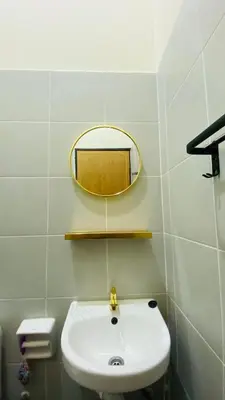 a bathroom with a white sink and a mirror at Prima Lodge Homestay in Kulim