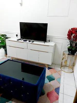 a living room with a tv on a white cabinet at Fz North Meru Impian in Ipoh