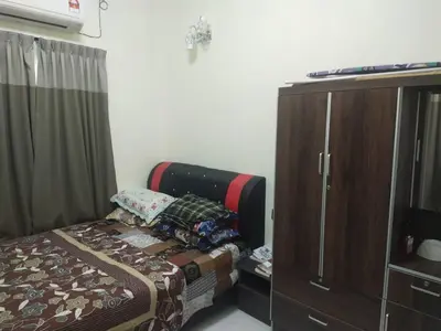 a bedroom with a bed and a wooden cabinet at Teratak Desa Cemerlang 2 in Kuala Kangsar