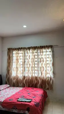 a bedroom with a bed with a red blanket and a window at Budjet Homestay CH in Tanah Rata