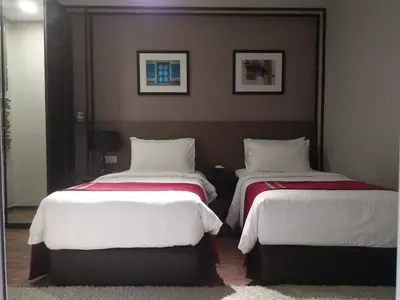 two beds in a hotel room with white and red sheets at Urbano Luxury Homestay at Maritime in George Town