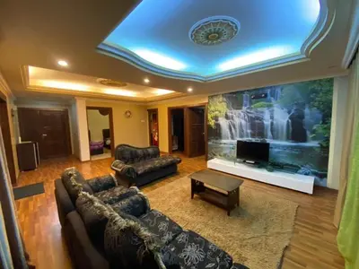 a living room with couches and a large screen tv at Crown Imperial Court - Arsad Homestay Brinchang in Brinchang