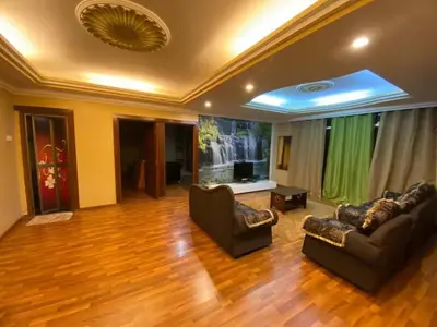a living room with two couches and a flat screen tv at Crown Imperial Court - Arsad Homestay Brinchang in Brinchang