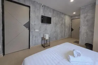 a bedroom with a bed and a tv on the wall at The Cozy Hotel in Sungai Petani