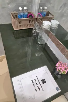 a table with bottles of water and flowers on it at The Cozy Hotel in Sungai Petani