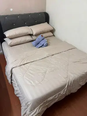 a unmade bed with a blue shirt on it at laman terrace stays in Sungai Petani