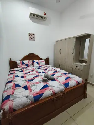 a bedroom with a large bed with avertisementatronatronstrationstrationstration at Bertam Wawasan Homestay in Kepala Batas