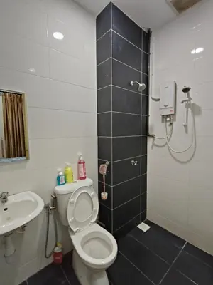 a bathroom with a shower and a toilet and a sink at Bertam Wawasan Homestay in Kepala Batas