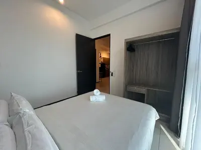 a bedroom with a white bed and a window at SeaView Premium Family Suite 3B2R in George Town