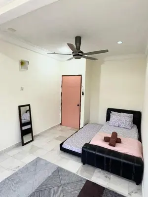 a bedroom with a bed and a ceiling fan at Ribat Homestay in Gerik