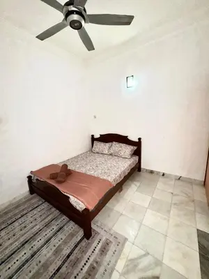 a bedroom with a bed with a ceiling fan at Ribat Homestay in Gerik