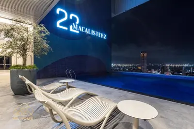two white chairs and tables on top of a building at 22Macalisterz by MC Home in George Town
