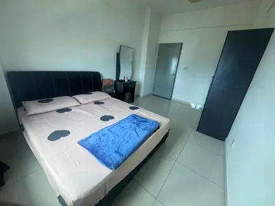 a bedroom with a bed with a blue blanket on it at BG Roomstay in Ipoh