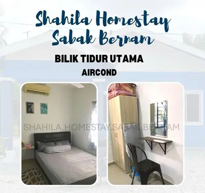 a bedroom with a bed and a desk in a room at Shahila Homestay Sabak Bernam