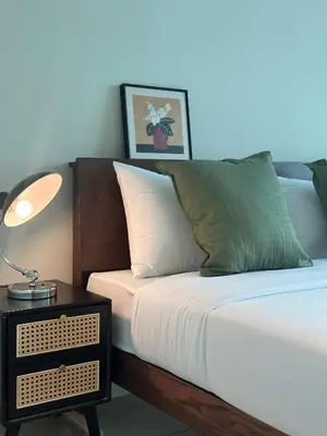 a bed with a side table with a lamp on it at Metropol by BRB in Bukit Mertajam