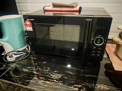 a microwave sitting on a counter with a blue appliance at The Crayon Shin-chan Themed Stay Family Ipoh By LUX SUITE in Ipoh