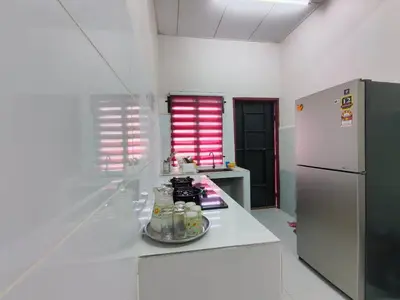 a kitchen with a white counter and a refrigerator at Nariz Homestay Kuala Ketil in Kuala Ketil