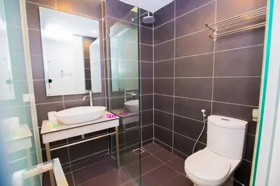 a bathroom with a toilet and a sink and a mirror at Urban Inn Kulim in Kulim