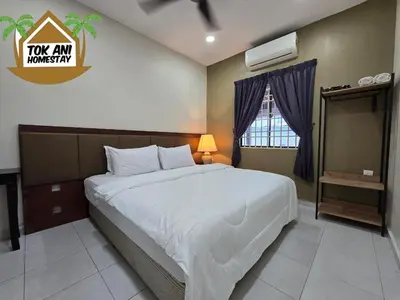 a bedroom with a large bed and a window at Homestay Tok Ani by Ardzman Hospitality in Permatang Pauh