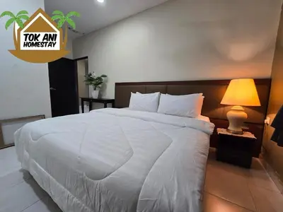 a bedroom with a large white bed with a lamp at Homestay Tok Ani by Ardzman Hospitality in Permatang Pauh