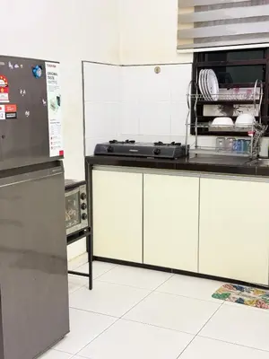 a kitchen with white cabinets and a refrigerator at Seri Pinggiran HOMESTAY Bertam Perdana in Kepala Batas